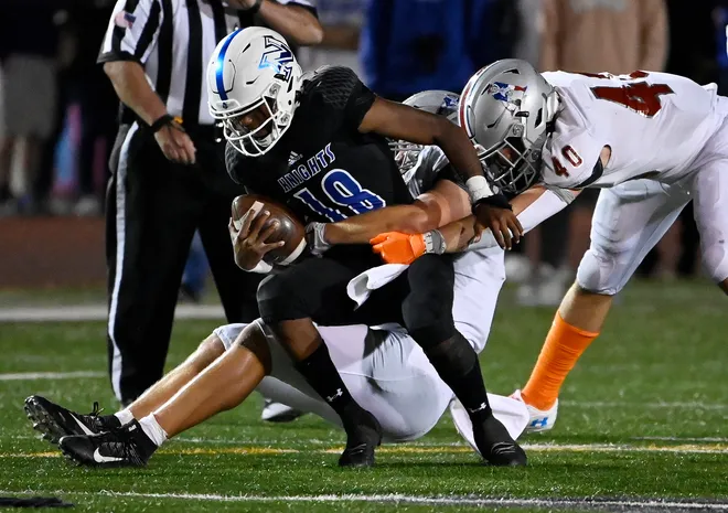 Intense football tackle during a Friday night game