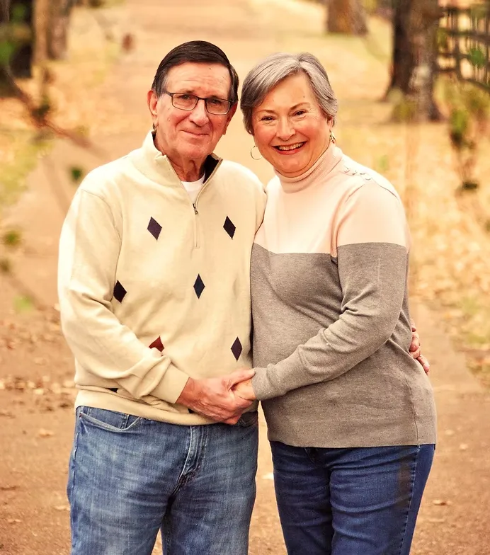 Founders Elmer and Anna Hill standing together on a tree-lined path